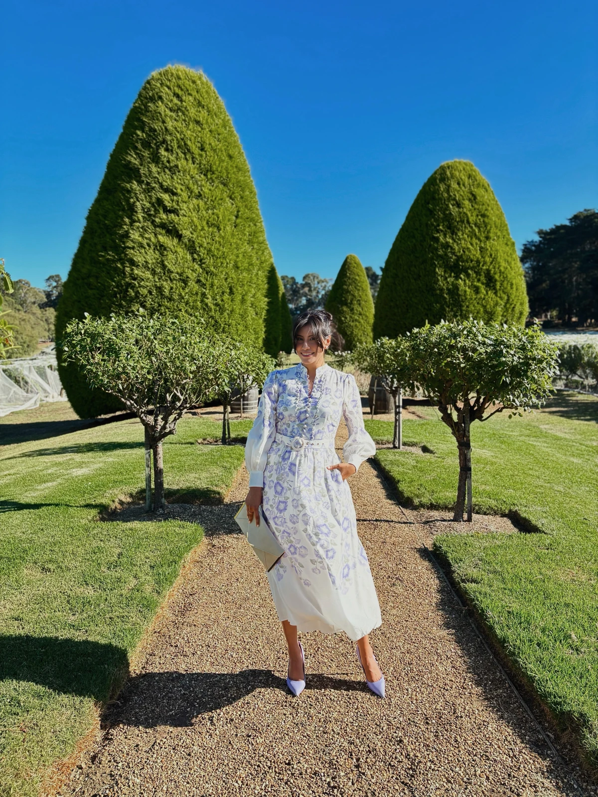 Millen Guerrero walking through manicured gardens on a travel shoot