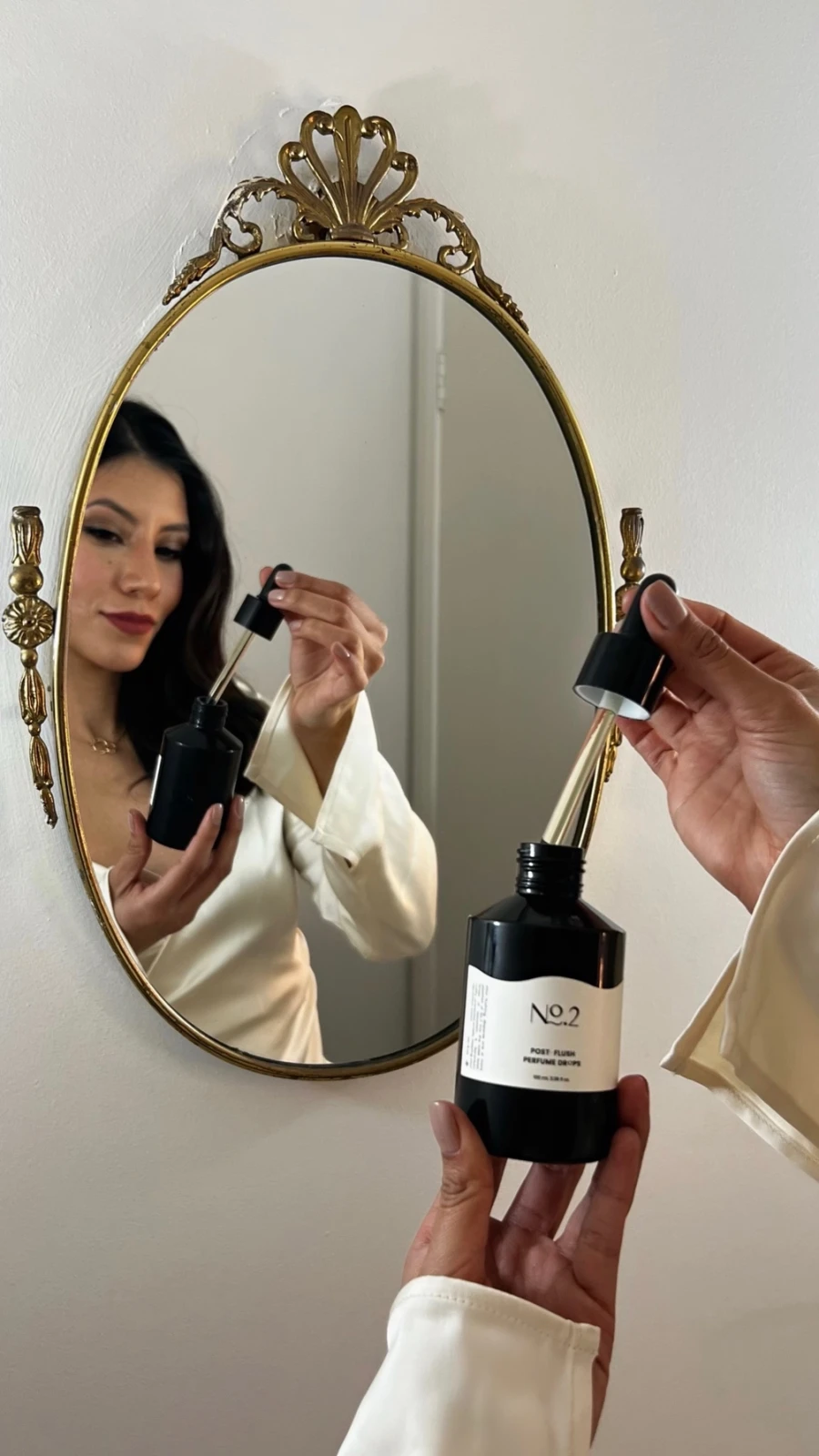 Millen Guerrero applying serum in front of an antique mirror
