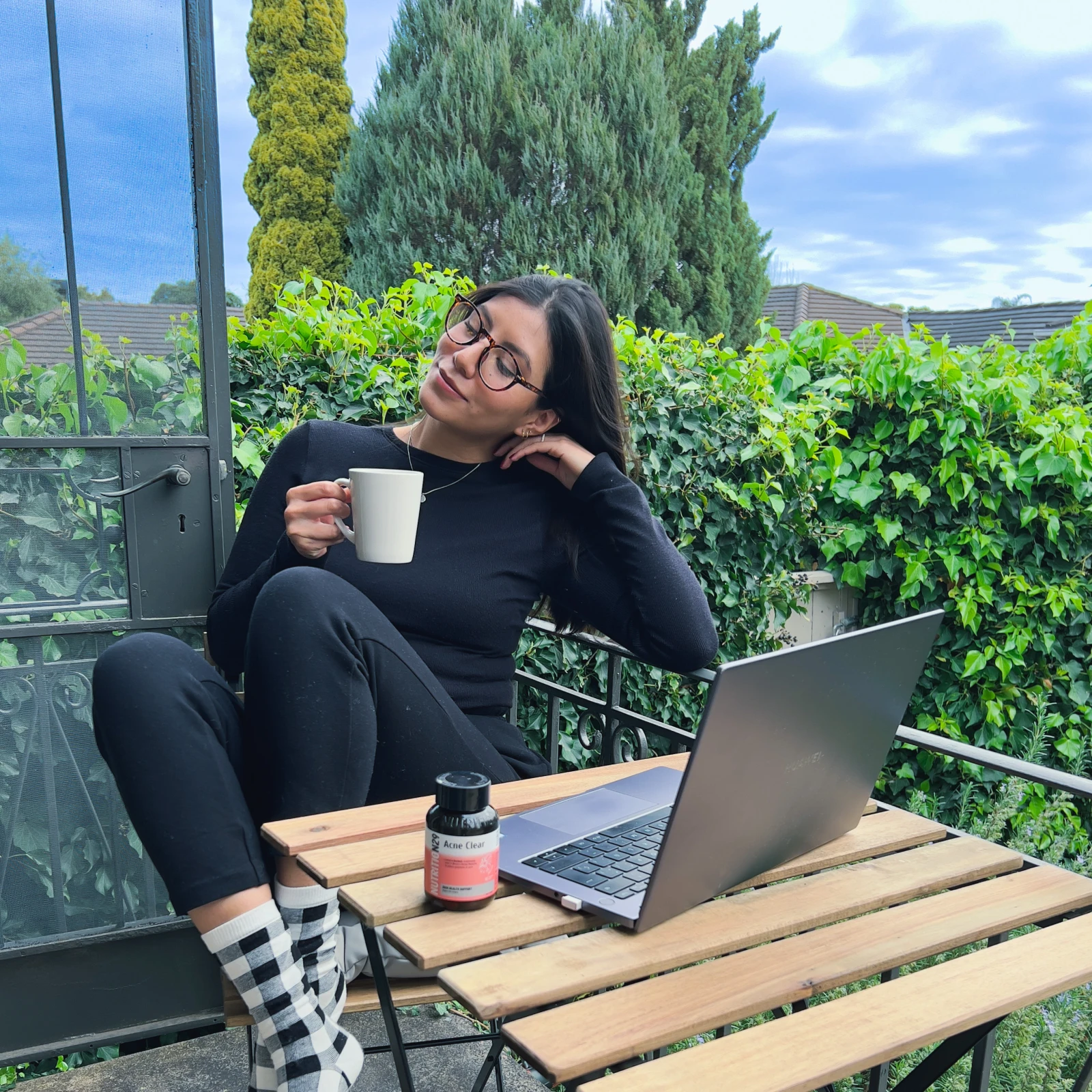 Millen Guerrero working outdoors with coffee on a sunlit balcony